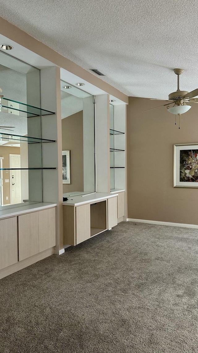 carpeted spare room with ceiling fan and a textured ceiling