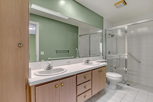 bathroom featuring tile patterned flooring, vanity, toilet, and walk in shower