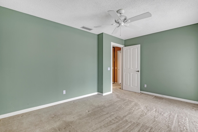 carpeted spare room featuring a textured ceiling and ceiling fan