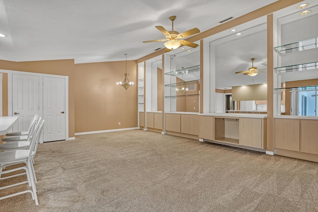 interior space with ceiling fan with notable chandelier, light carpet, and high vaulted ceiling