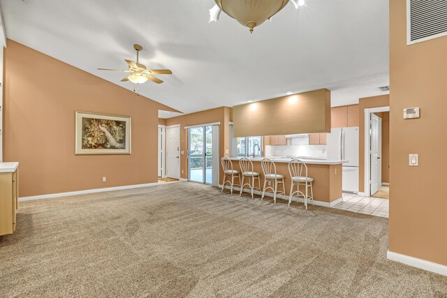 unfurnished living room featuring light carpet, sink, vaulted ceiling, and ceiling fan