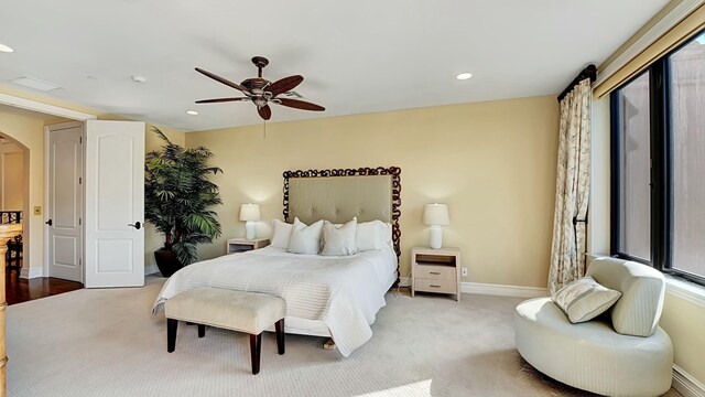 carpeted bedroom with baseboards, arched walkways, ceiling fan, and recessed lighting