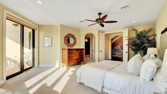 bedroom with light carpet, access to outside, visible vents, and arched walkways