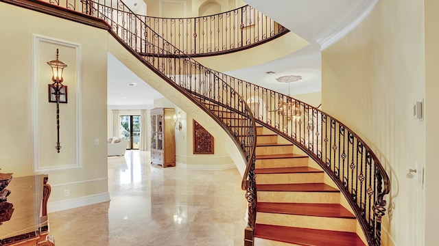 stairway featuring ornamental molding and a high ceiling