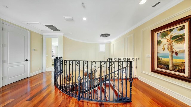 hall featuring visible vents, crown molding, an upstairs landing, and wood finished floors