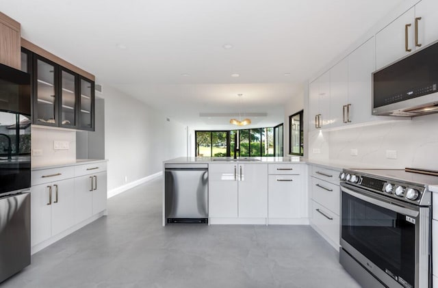 kitchen featuring white cabinetry, appliances with stainless steel finishes, kitchen peninsula, pendant lighting, and backsplash