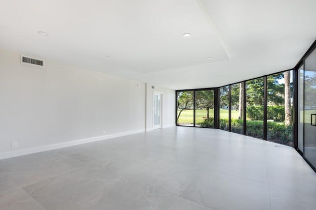 spare room featuring a wall of windows and a healthy amount of sunlight