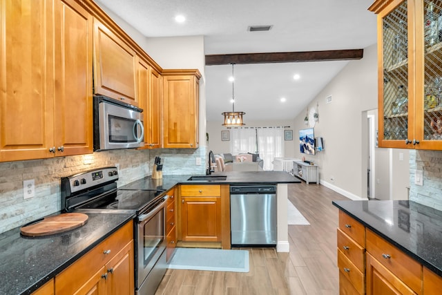 kitchen with sink, light wood-type flooring, tasteful backsplash, and stainless steel appliances