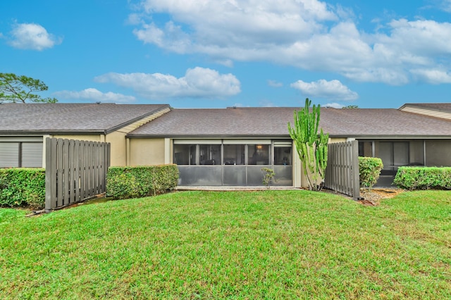 rear view of property with a sunroom and a yard