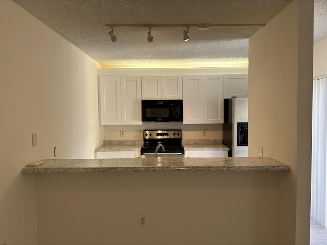 kitchen with a textured ceiling, white cabinetry, light stone countertops, and appliances with stainless steel finishes