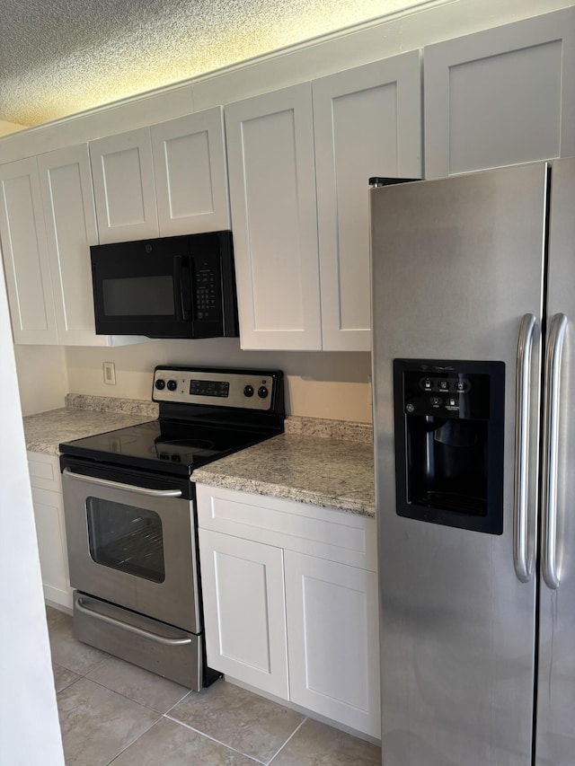 kitchen featuring light tile patterned flooring, white cabinets, and appliances with stainless steel finishes