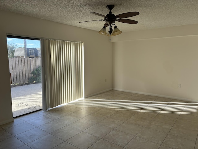 tiled spare room with ceiling fan and a textured ceiling