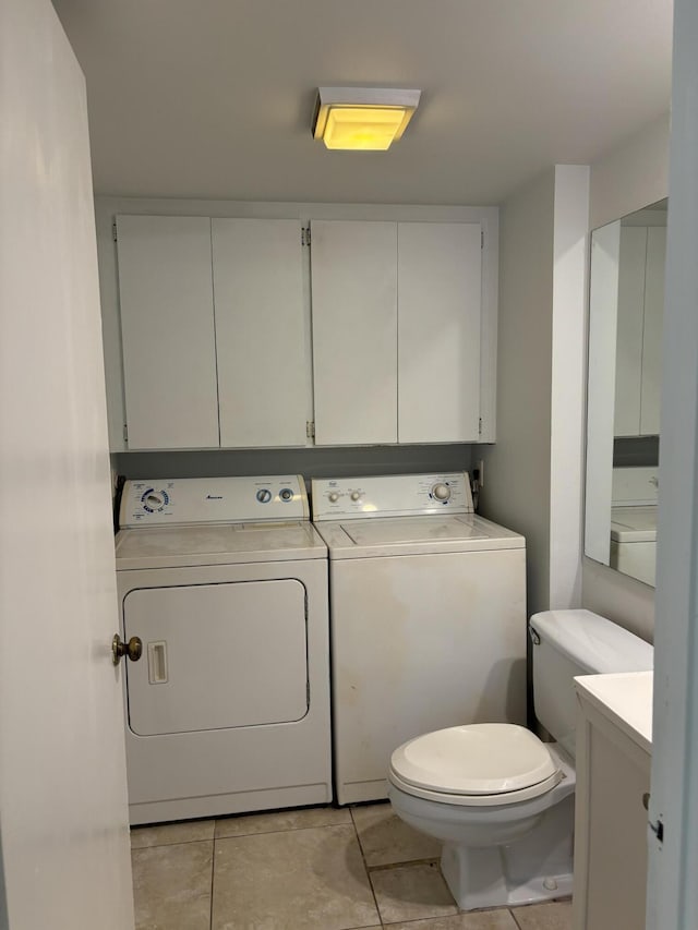 bathroom featuring toilet, vanity, washing machine and dryer, and tile patterned flooring