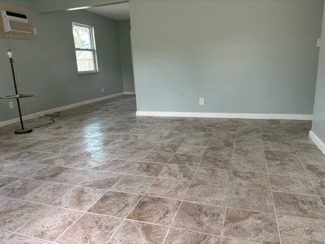 empty room featuring a wall mounted AC and tile patterned floors