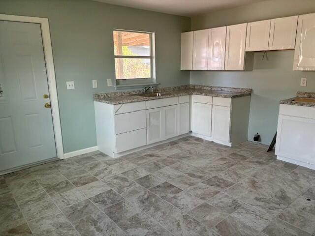 kitchen featuring sink and white cabinetry