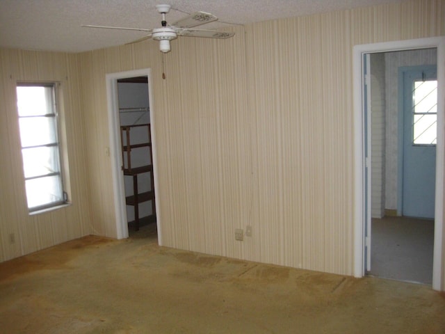 empty room with ceiling fan and light carpet