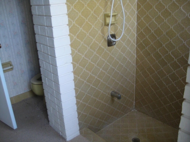 bathroom with toilet and tiled shower