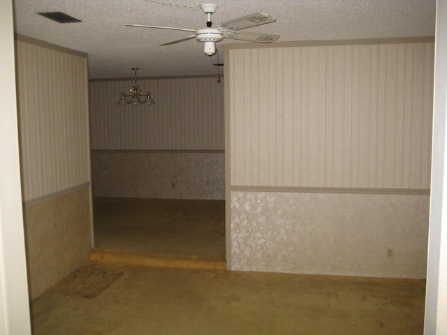 empty room with ceiling fan and a textured ceiling