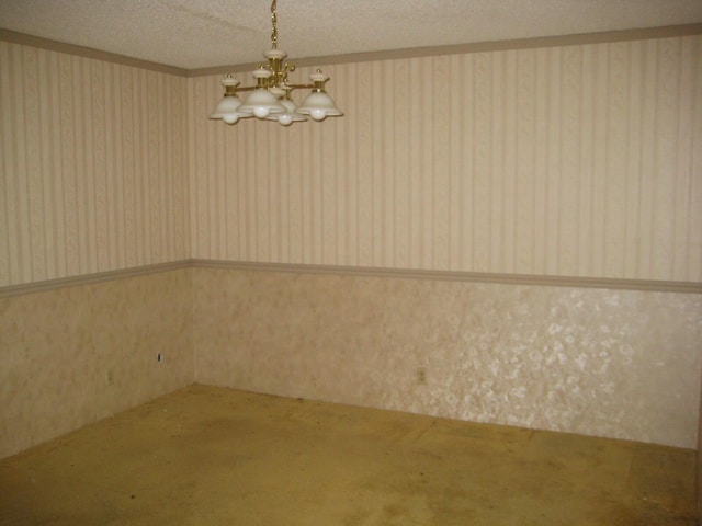 carpeted empty room with a chandelier