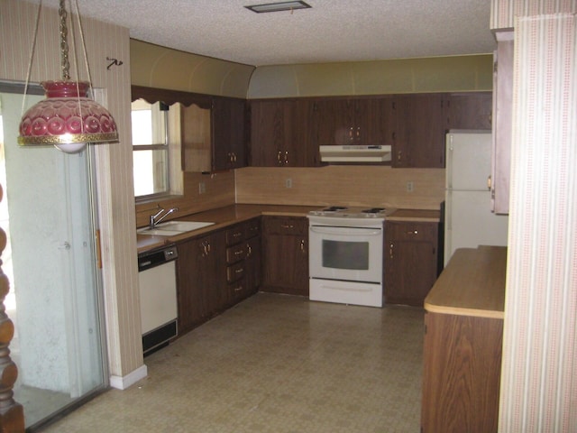 kitchen with sink, dark brown cabinets, white appliances, and a textured ceiling