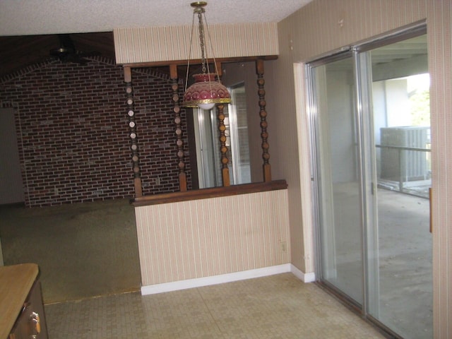 unfurnished dining area featuring brick wall