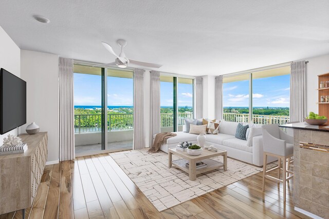 living room featuring ceiling fan, floor to ceiling windows, and light hardwood / wood-style flooring