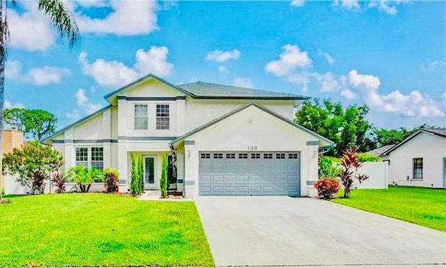 front of property featuring a front lawn and a garage