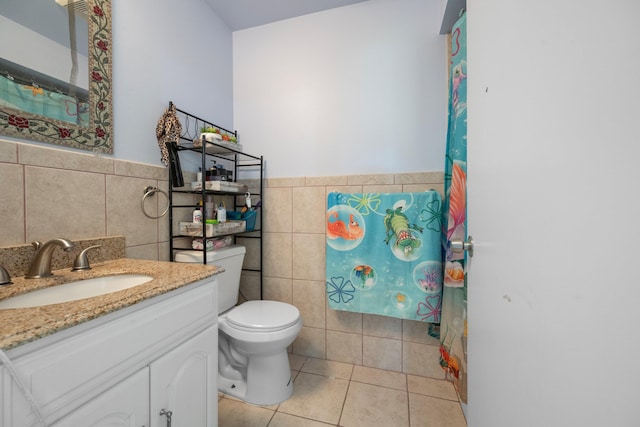 bathroom with vanity, tile walls, tile patterned floors, and toilet