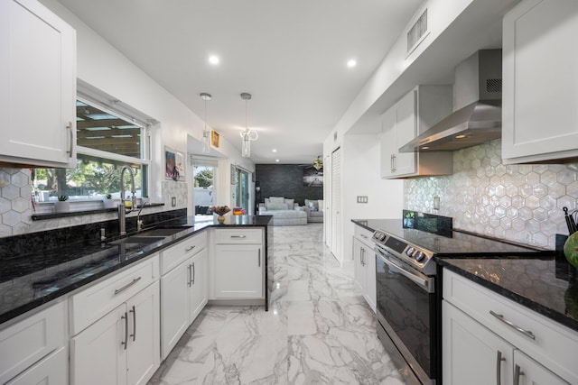 kitchen with sink, white cabinetry, dark stone countertops, stainless steel electric stove, and wall chimney range hood