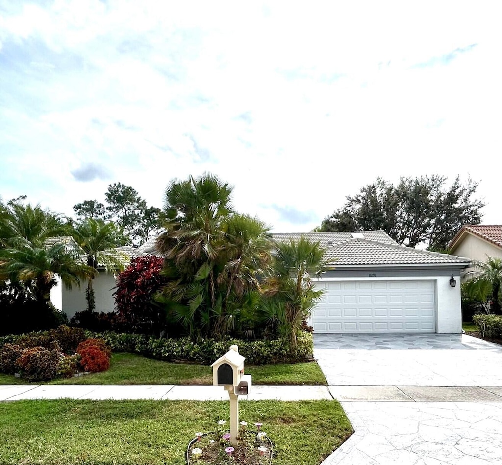 view of front of property featuring a front yard and a garage