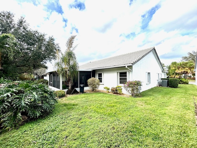 back of property with a lawn, central AC, and a sunroom