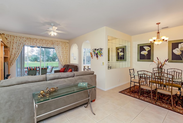 living room featuring light tile patterned floors and ceiling fan with notable chandelier