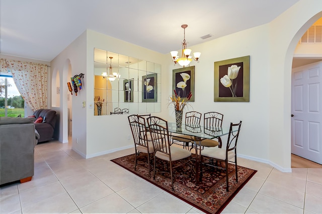 tiled dining room with a notable chandelier