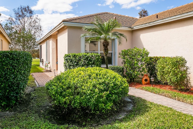 306 SW Tomoka Springs Dr, Port Saint Lucie, FL 34986 - view of side of home with stucco siding, a tile roof, and a yard
