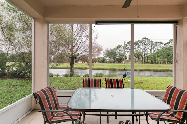 sunroom featuring a water view and ceiling fan