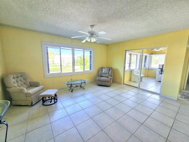 unfurnished room with light tile patterned floors, baseboards, a textured ceiling, and ceiling fan