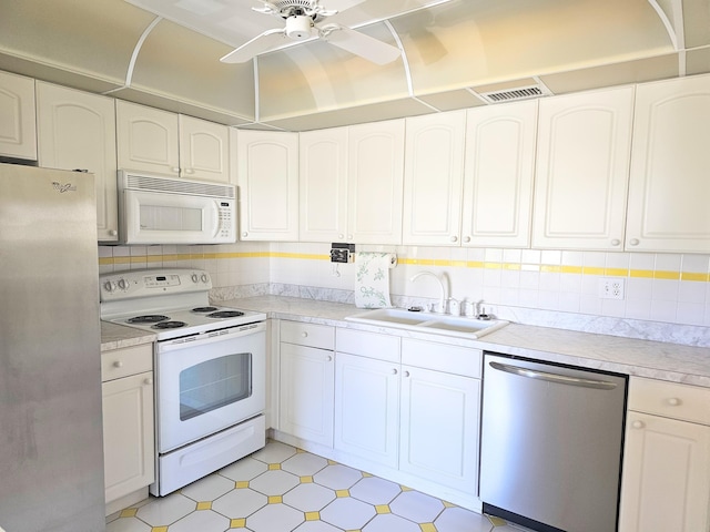 kitchen with tasteful backsplash, visible vents, appliances with stainless steel finishes, a ceiling fan, and a sink