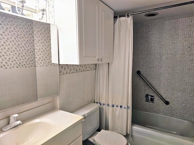 full bath with toilet, vanity, tile walls, and shower / tub combo with curtain