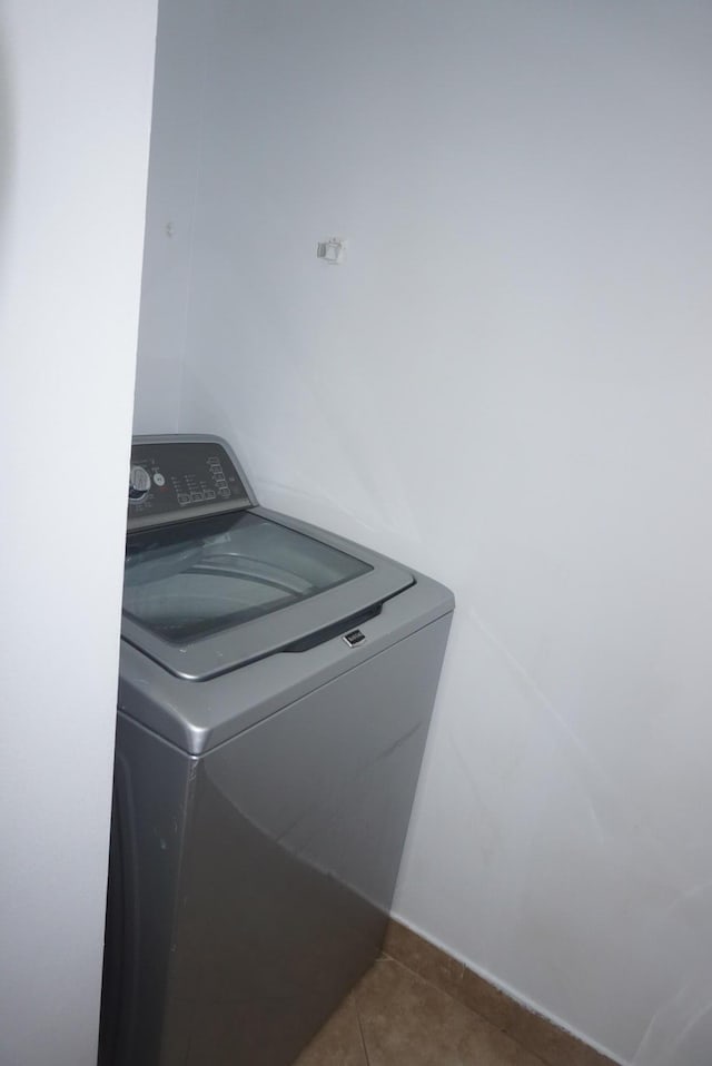 washroom with dark tile patterned flooring and washer / clothes dryer