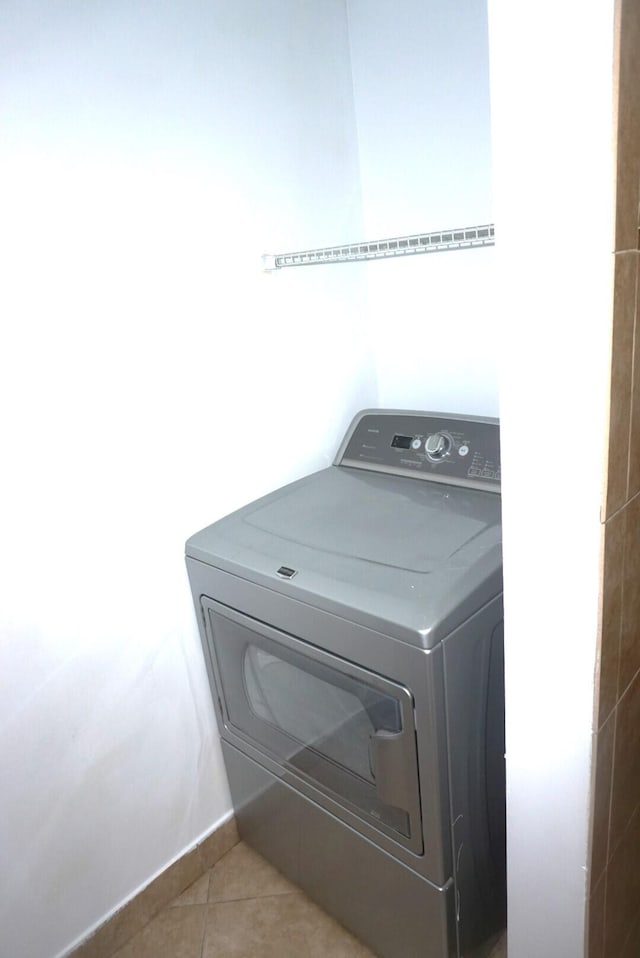 clothes washing area featuring washer / dryer and light tile patterned floors