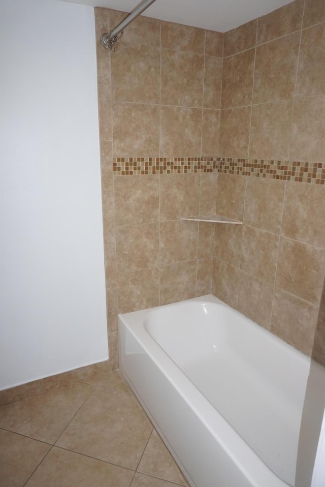 bathroom featuring tiled shower / bath combo and tile patterned flooring