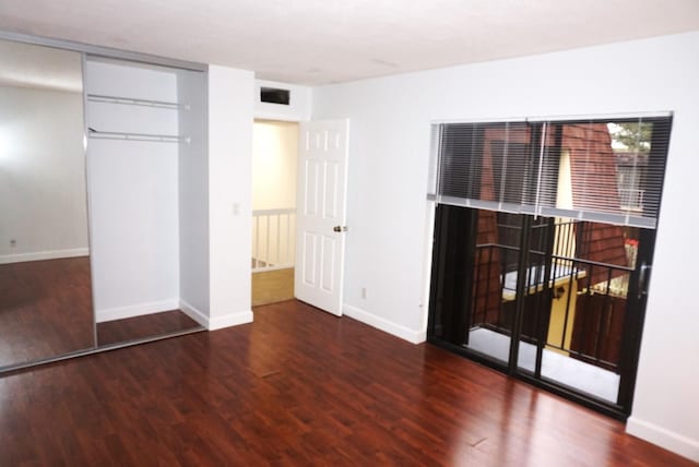 unfurnished bedroom with a closet and dark hardwood / wood-style floors