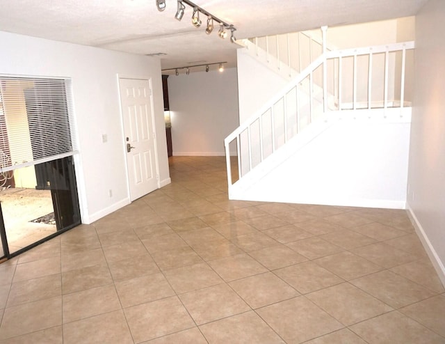 tiled empty room with a textured ceiling