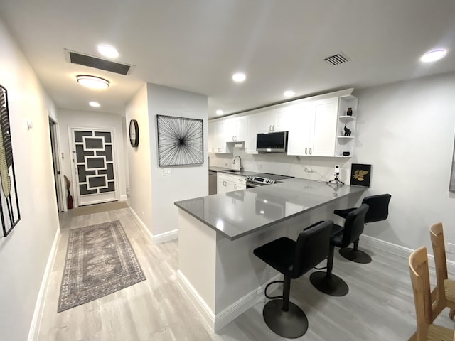 kitchen with open shelves, visible vents, stainless steel appliances, and a sink