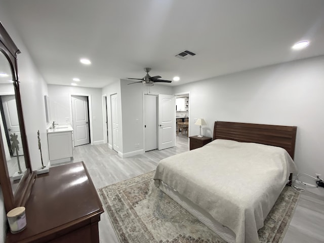 bedroom with ceiling fan, light hardwood / wood-style floors, and sink