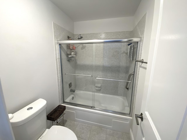 bathroom featuring toilet, shower / bath combination with glass door, and tile patterned flooring