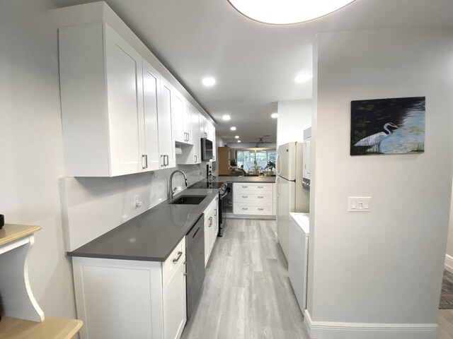 kitchen featuring kitchen peninsula, sink, white cabinetry, light wood-type flooring, and white refrigerator