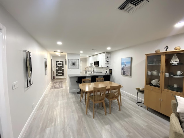 dining space featuring sink and light hardwood / wood-style flooring