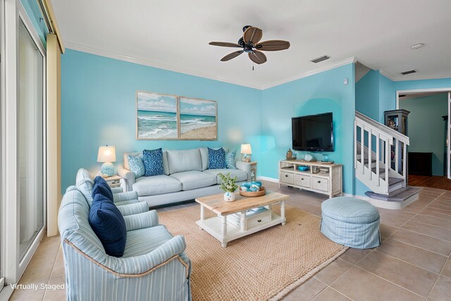 living room with light tile patterned floors, ornamental molding, and ceiling fan