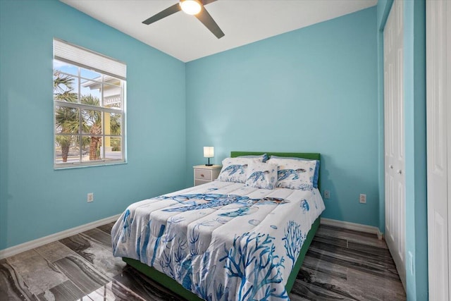 bedroom featuring ceiling fan, dark hardwood / wood-style floors, and a closet